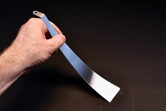 Yoshikawa EATCO Tolu Spatula — hand holding handle showing full blade face and tapered tip