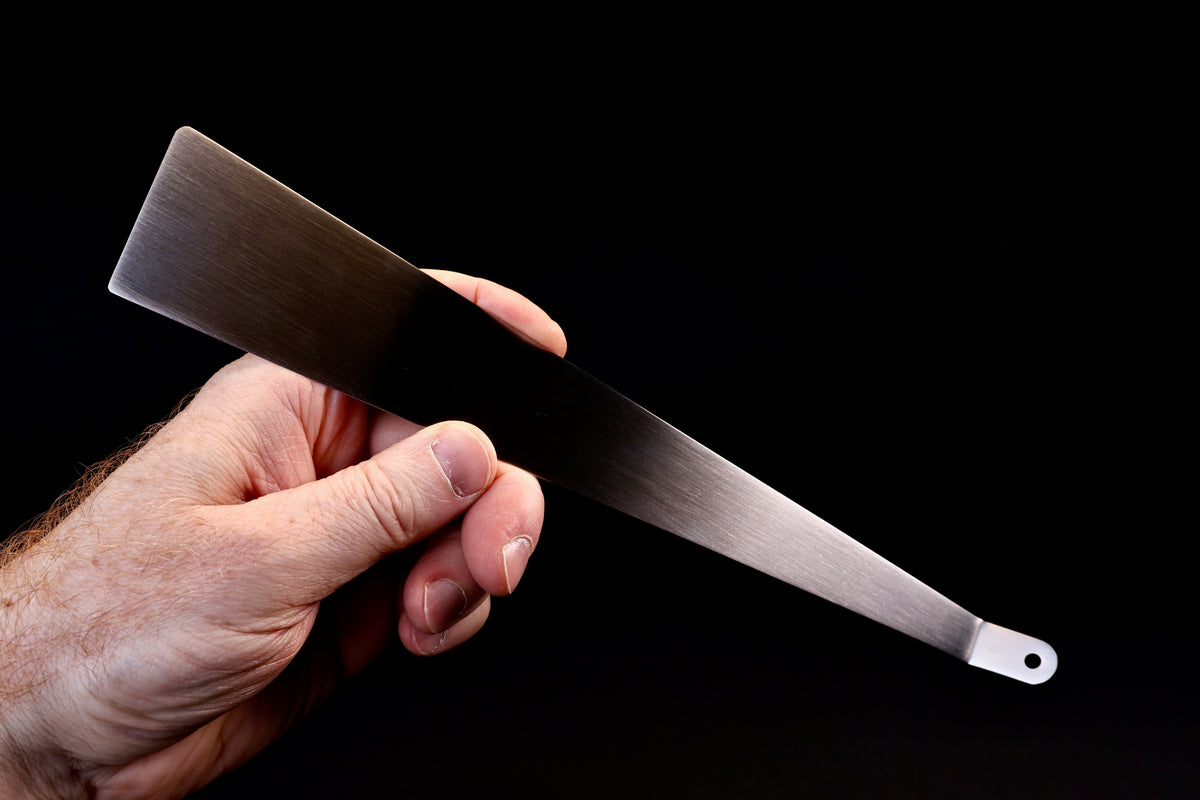 Yoshikawa EATCO Tolu Spatula — hand held from back showing wide blade tip and full tapered body